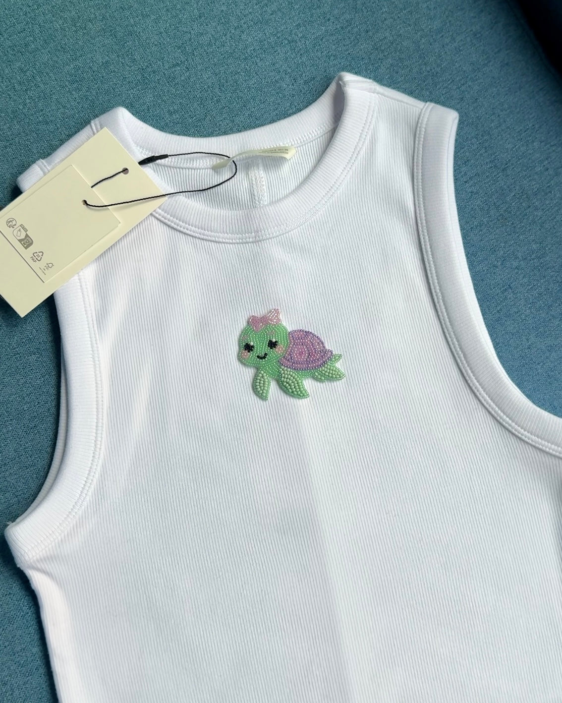 Original white ribbed top with mint-green and lilac beaded turtle