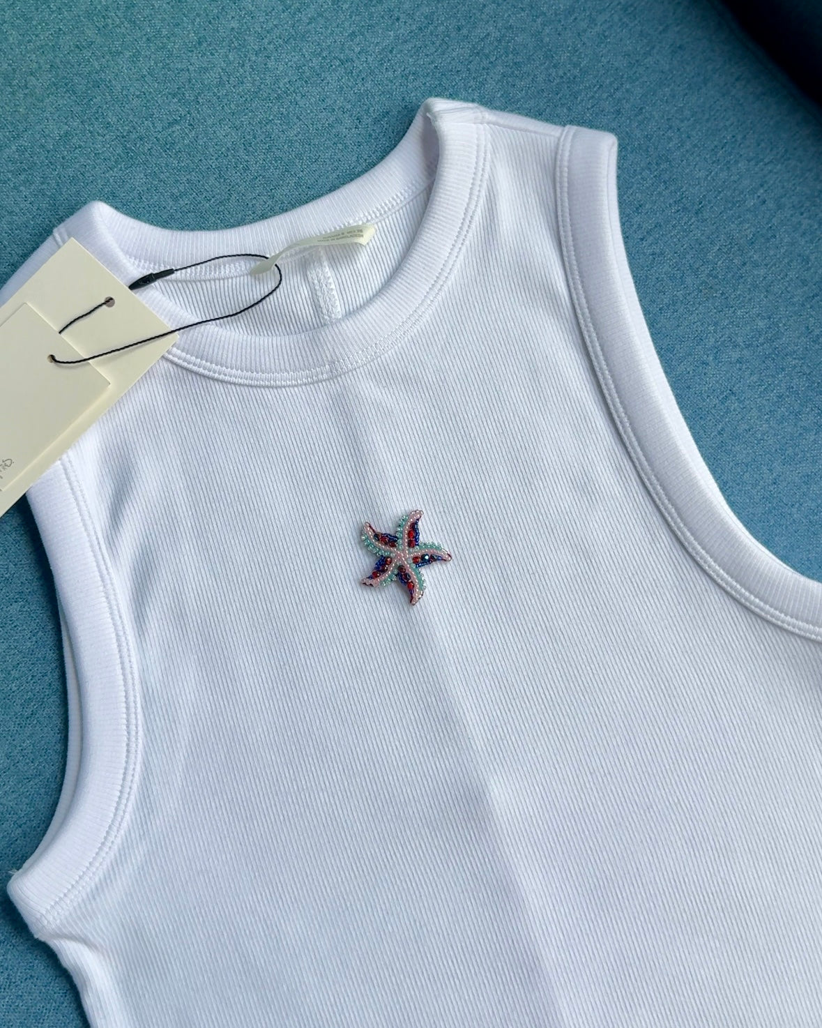 Original white ribbed tank with small multicolour beaded starfish