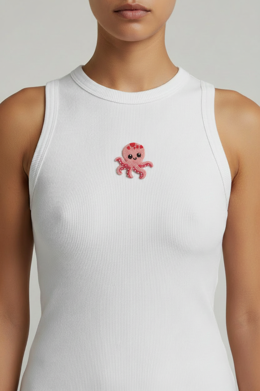Close-up of a white ribbed top with a centered pink beaded octopus motif