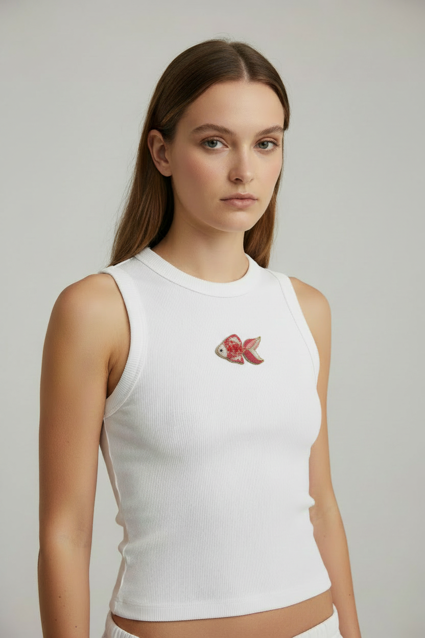 Model wearing white ribbed top with pink fish beadwork centered on the chest