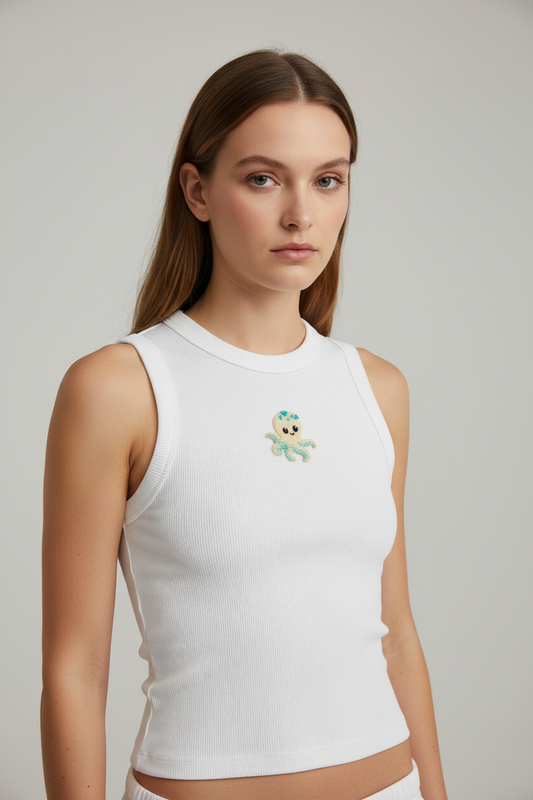 White ribbed top with a centered handmade yellow and turquoise beaded octopus motif, worn by a model at a slight right-side angle