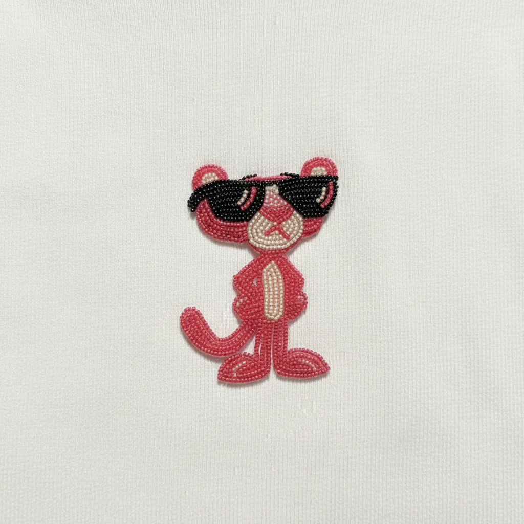 Pink Panther beadwork close-up on cream hoodie fabric